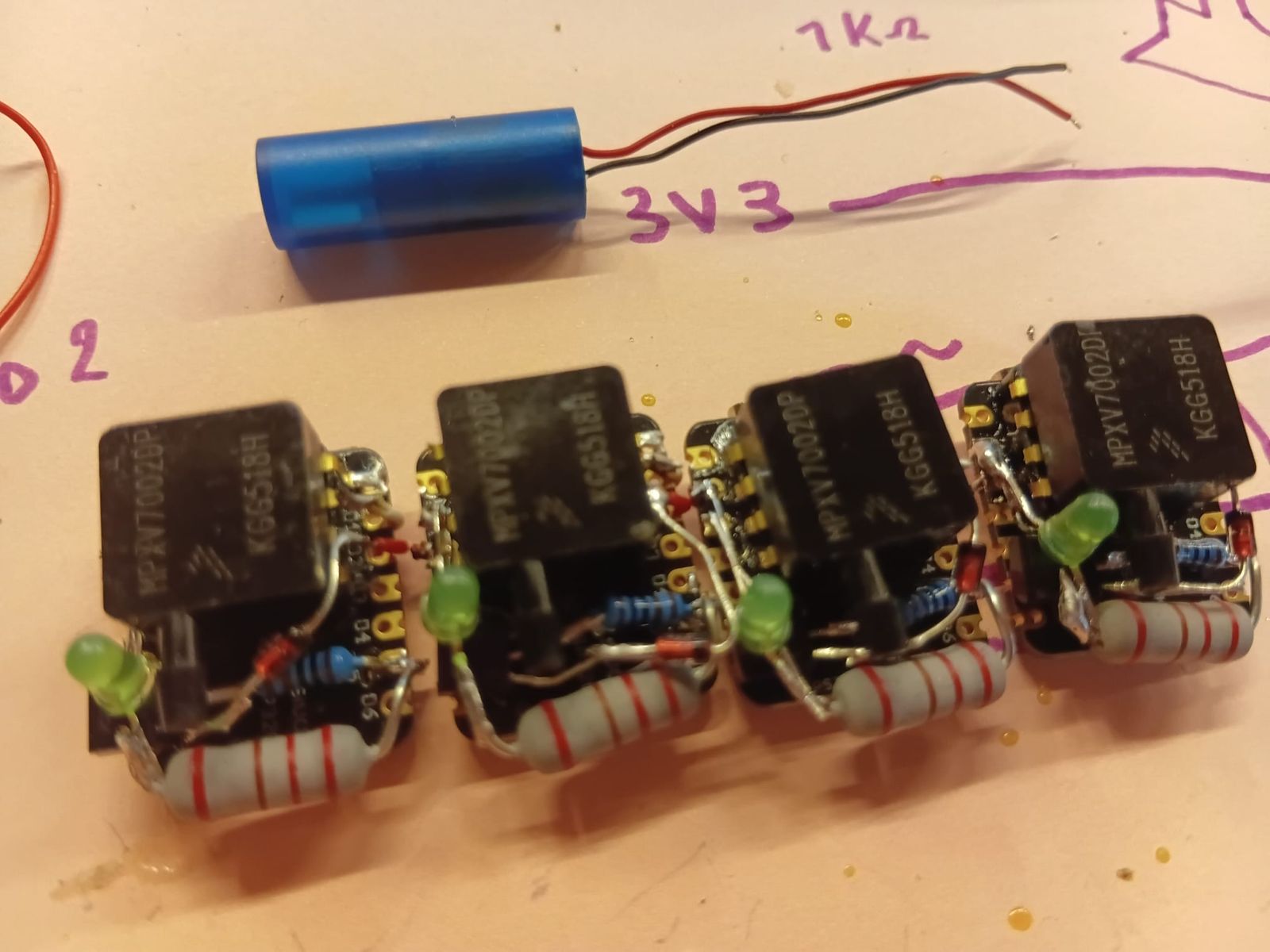 Four compact soldered circuits, each with an MPXV7002DP pressure sensor, a green LED, a diode and resistors on an ESP32-C3 board.